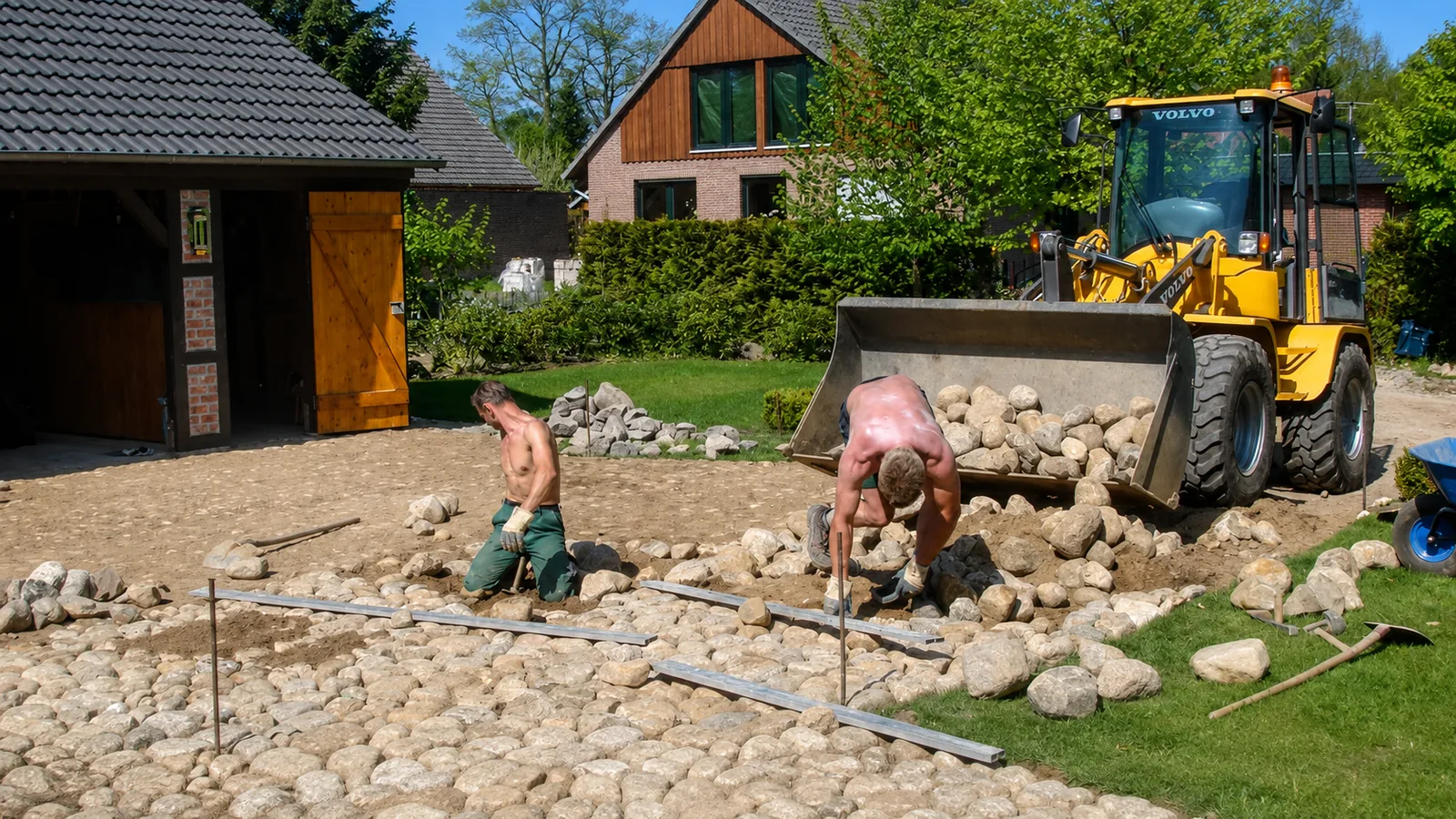 Symbolbild: Pflasterarbeiten an einem Natursteinbett, Radlader im Hintergrund
