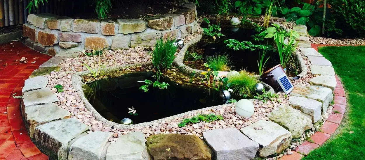 Angelegter Gartenteich mit Natursteinrand