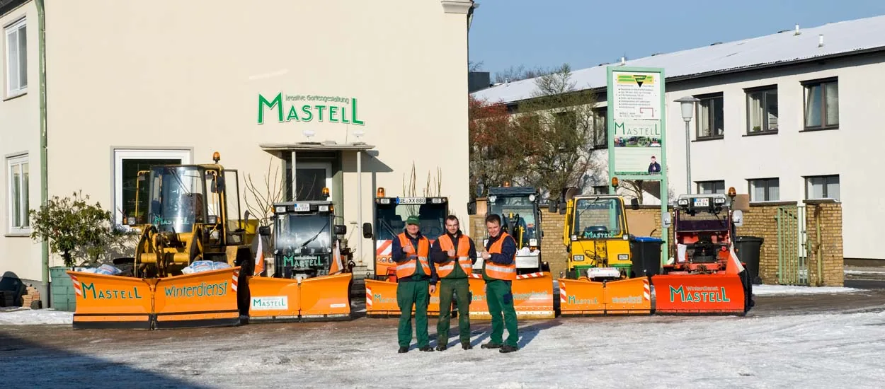 Geräumter Gehweg entlang einer verschneiten Hecke